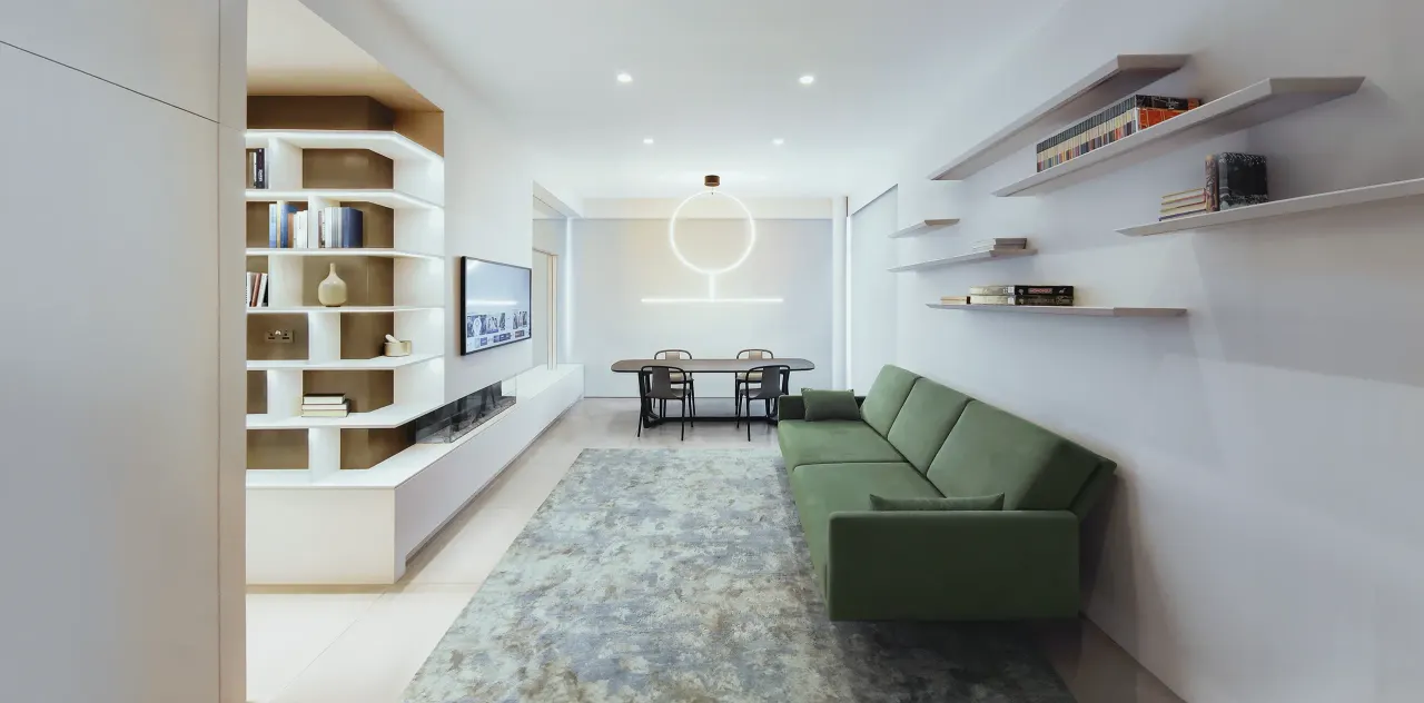 Living room with green sofa, built-in white shelving and dining table