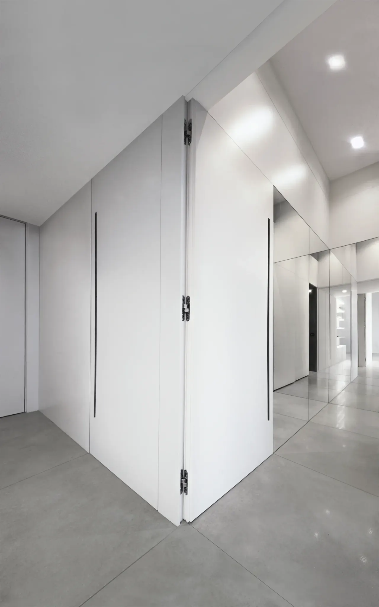 Hidden white doors set into a flush wall panel along the hallway