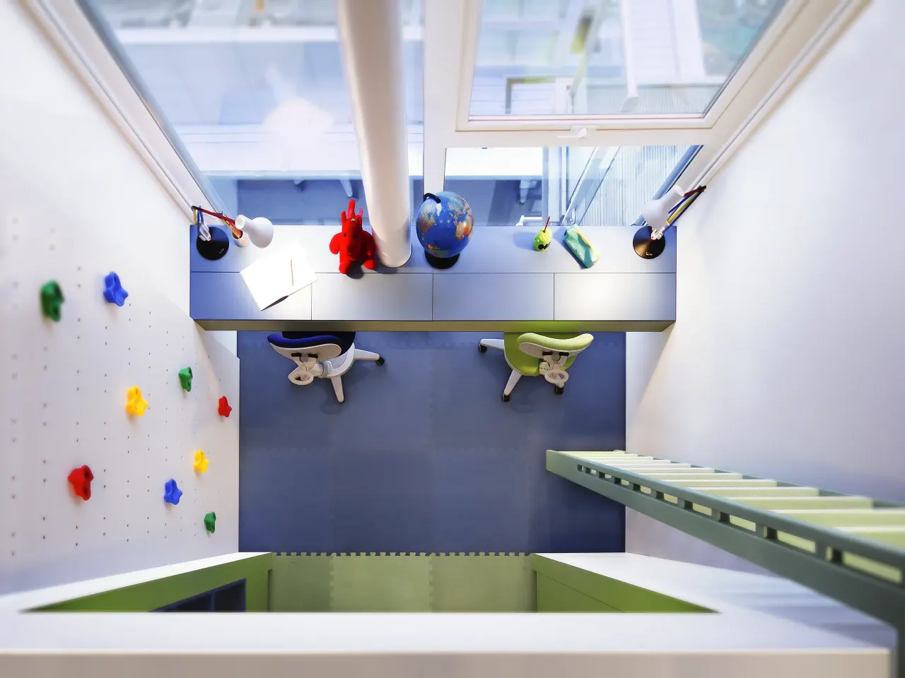 Children's room seen from above: climbing wall, blue floor and two desks