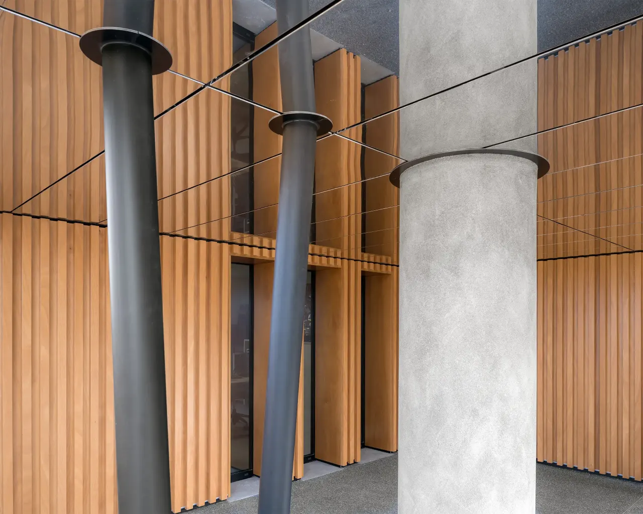 Timber fins, slanted steel columns and a concrete pillar under the building