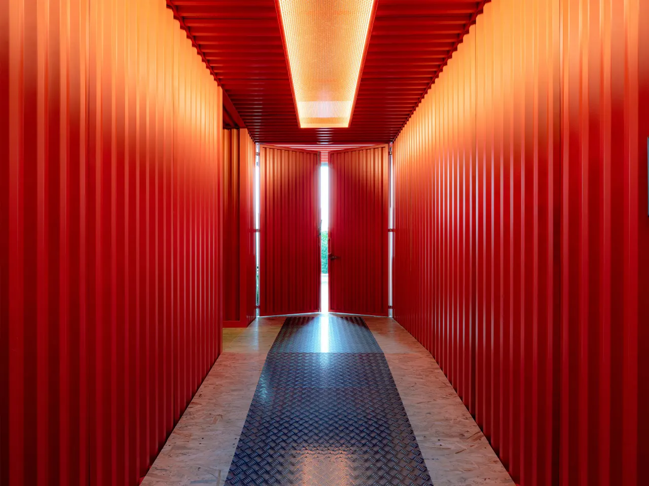 Corridor lined with red corrugated container panels