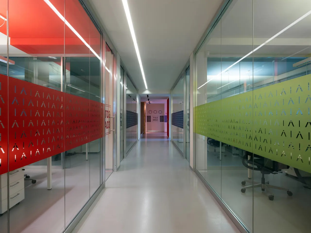 Glass-walled corridor with red and green patterned film