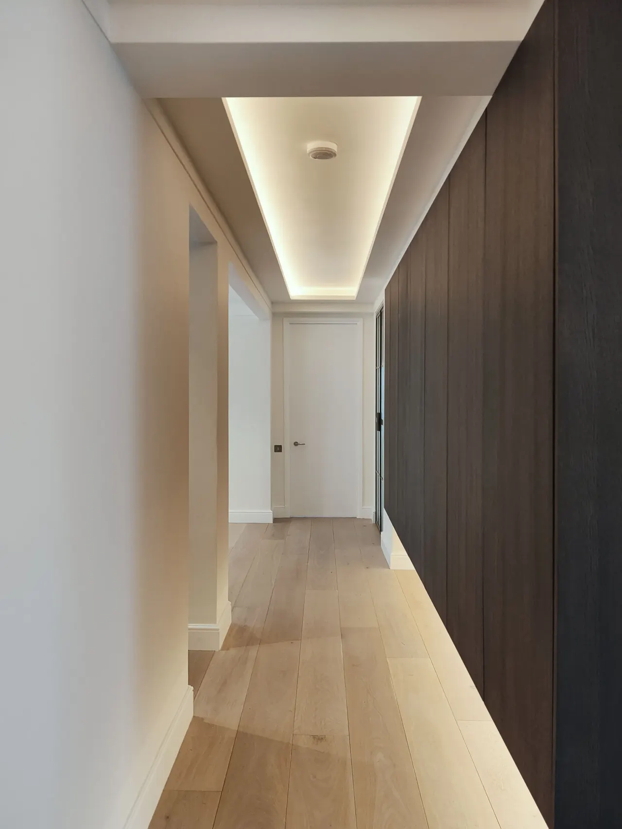 Hallway with concealed lighting and dark oak full-height joinery