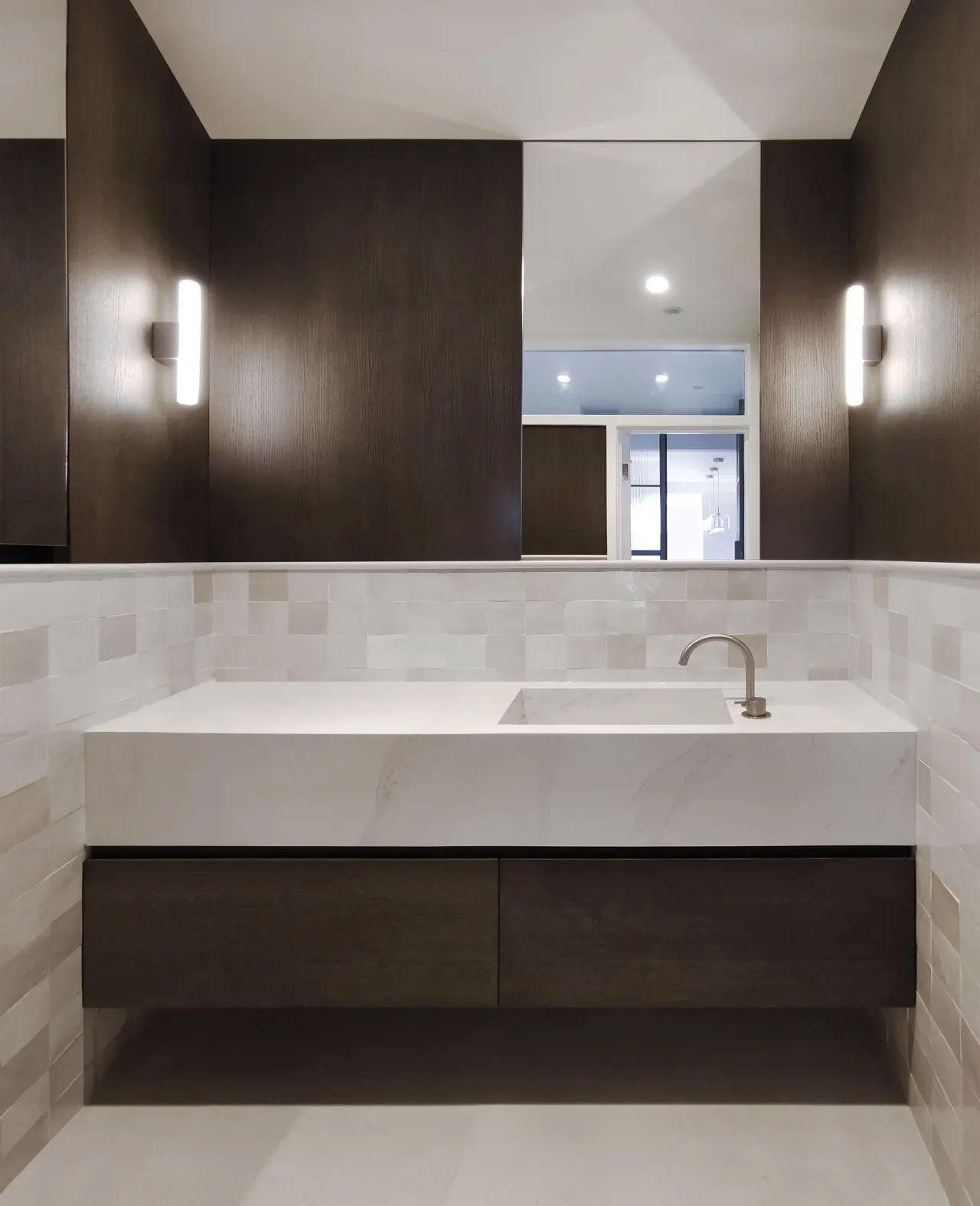Floating stone washbasin with dark oak drawers and wall lights
