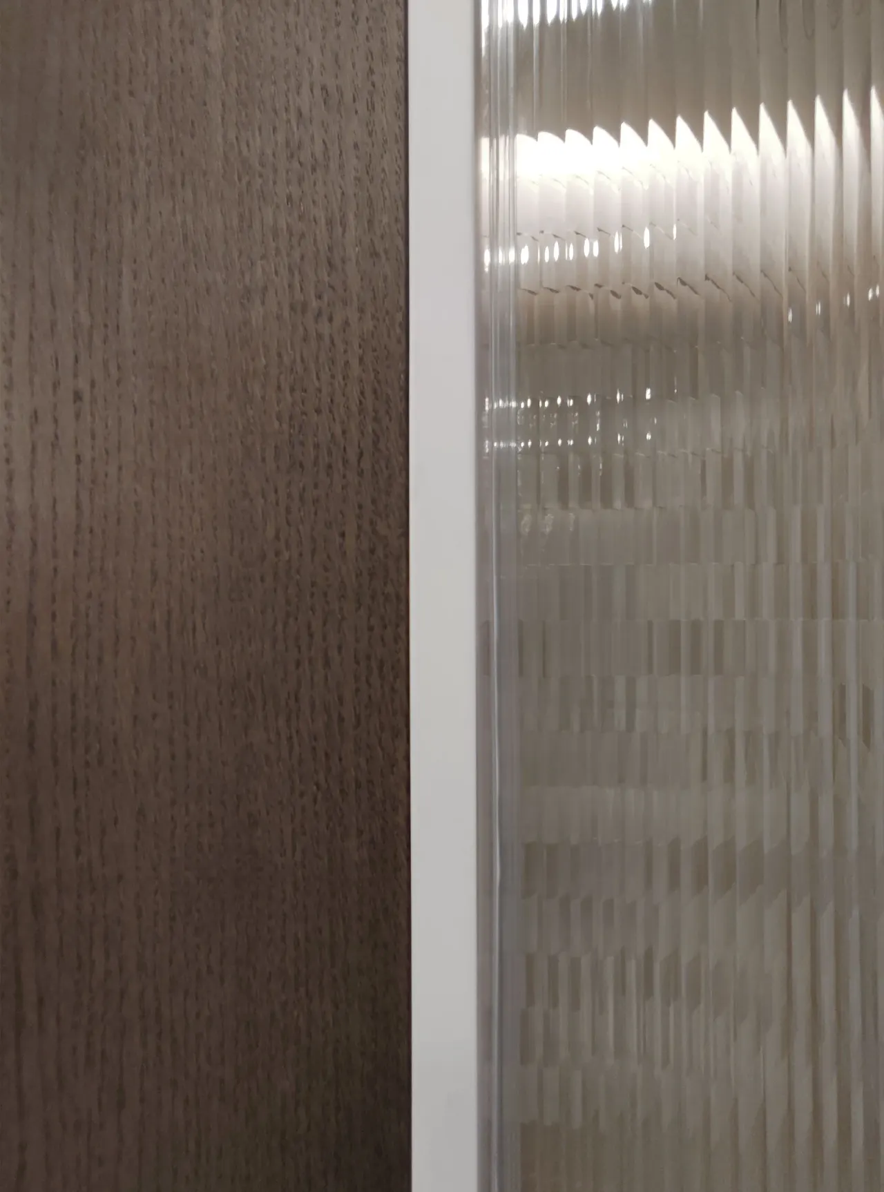 Detail of dark oak panel next to reeded glass