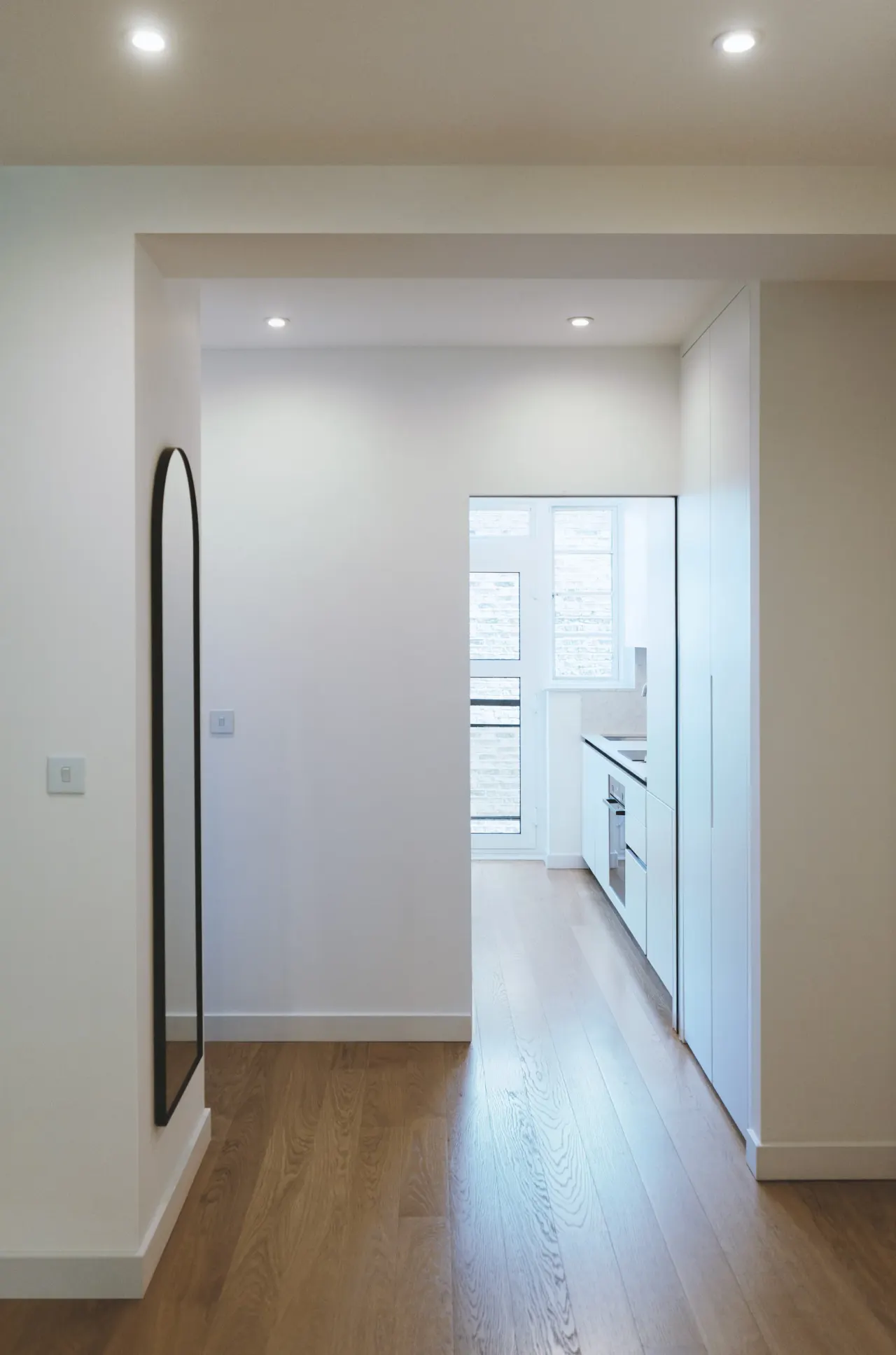 Hallway leading to the white kitchen
