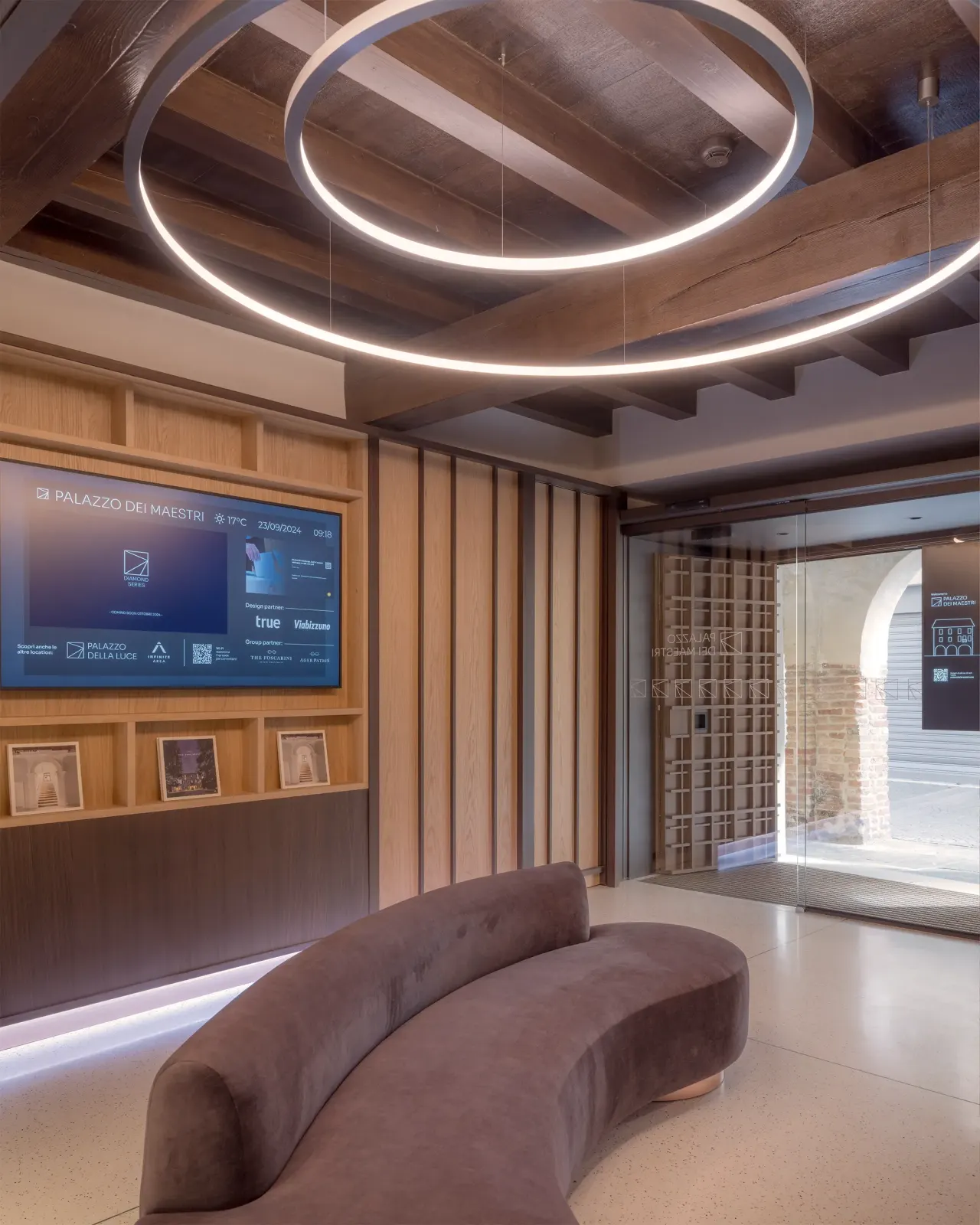 Lobby with circular light, curved sofa, timber ceiling and digital screen