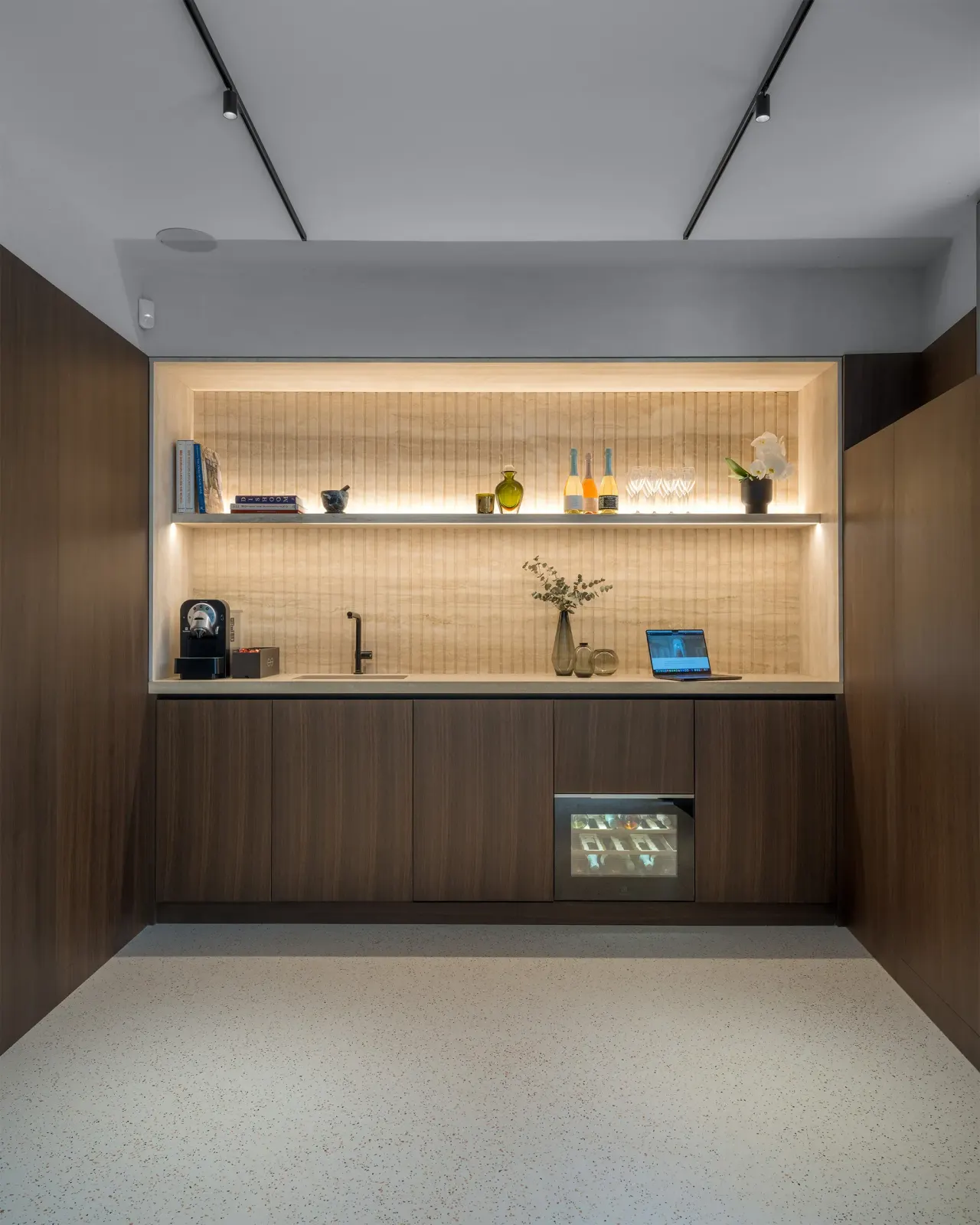 Break area with dark timber units and lit open shelving