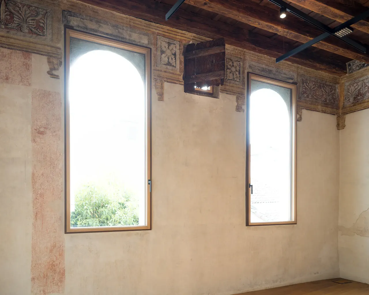 Room with arched windows, painted frieze and timber ceiling
