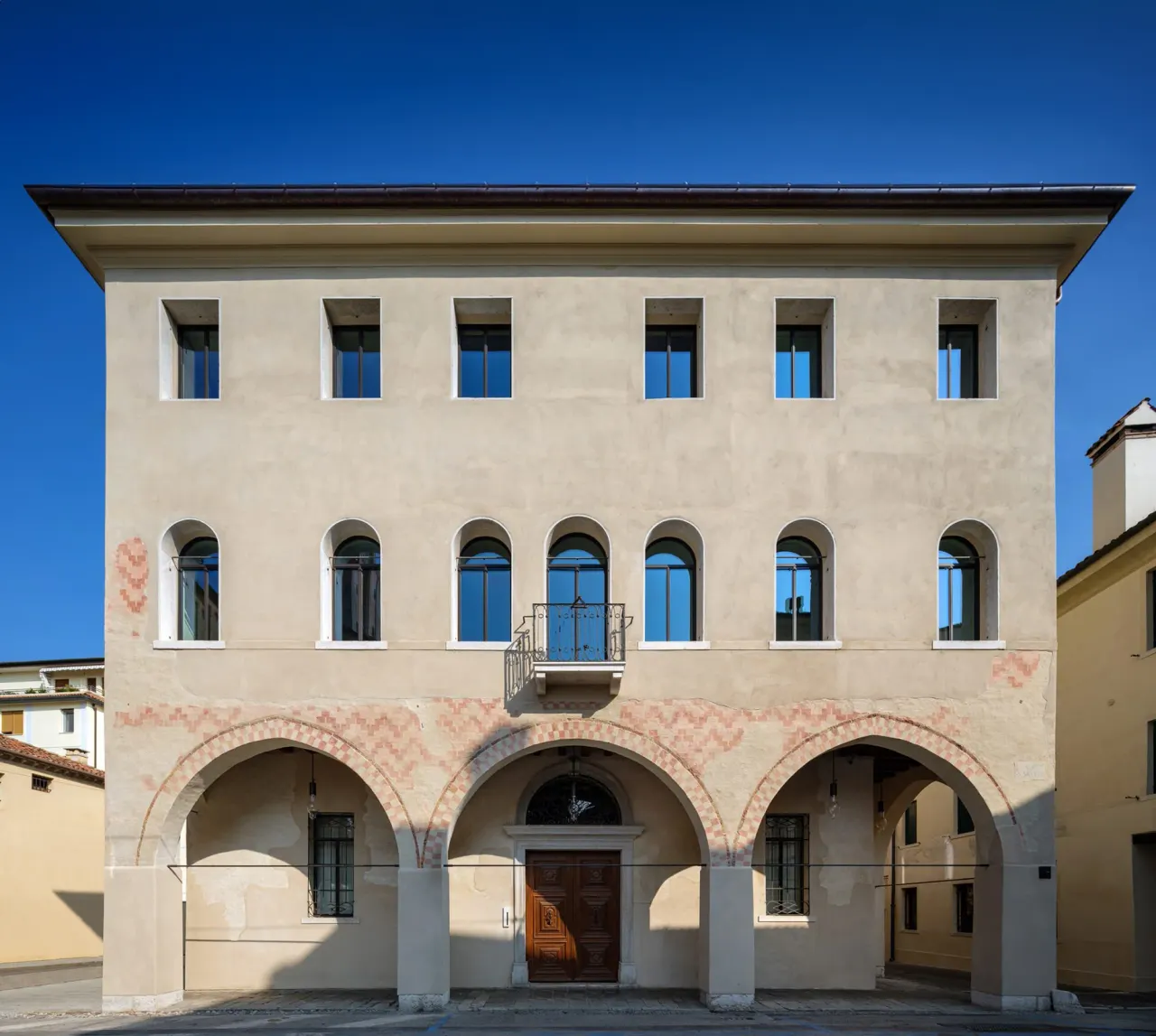 Restored palazzo facade with arched portico on the street