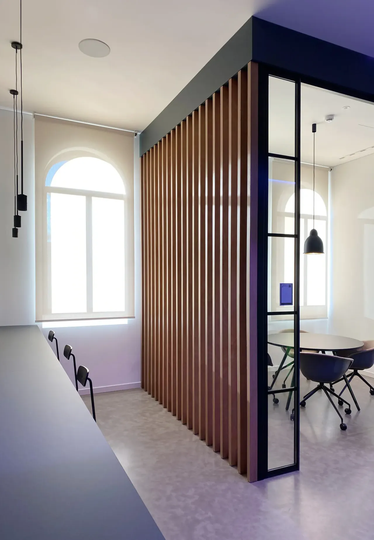 Timber-slatted meeting room with black-framed glass walls