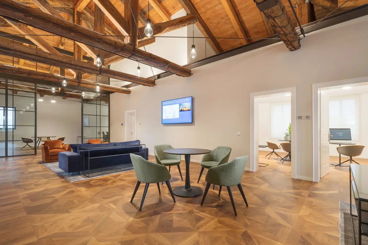 Open-plan attic with exposed roof trusses, sofas and meeting tables