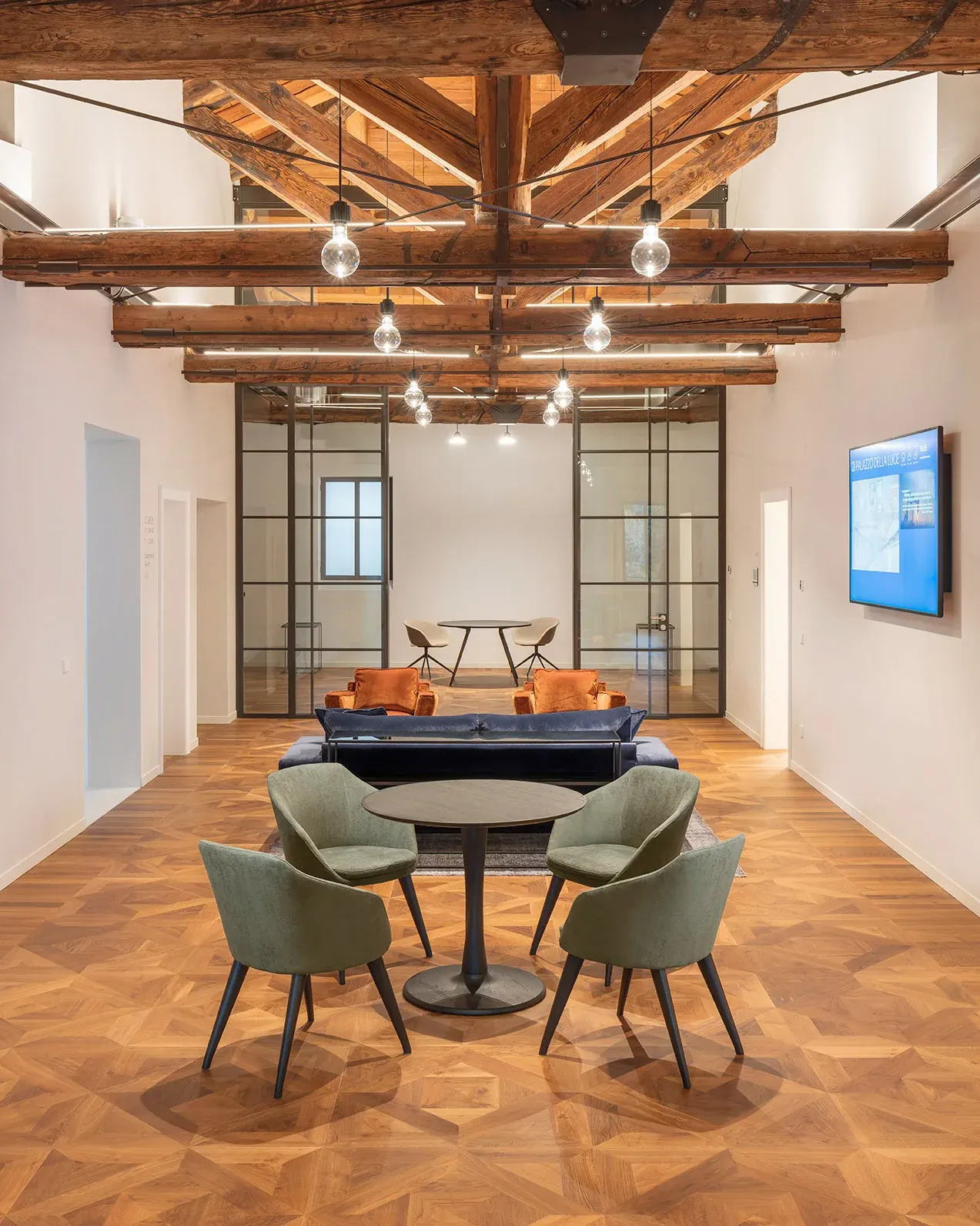 Meeting area with green chairs under the exposed timber roof