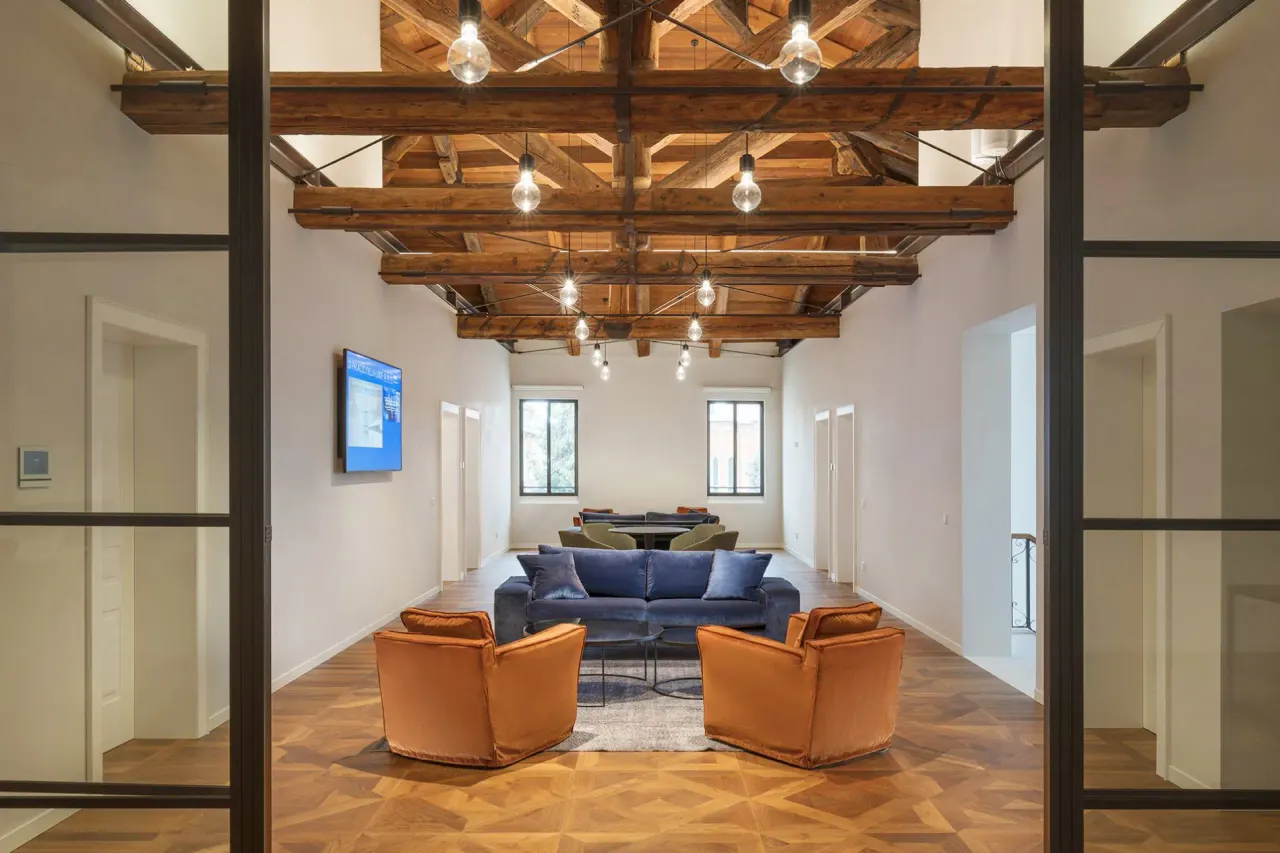 Seating area under the timber roof seen through glass doors