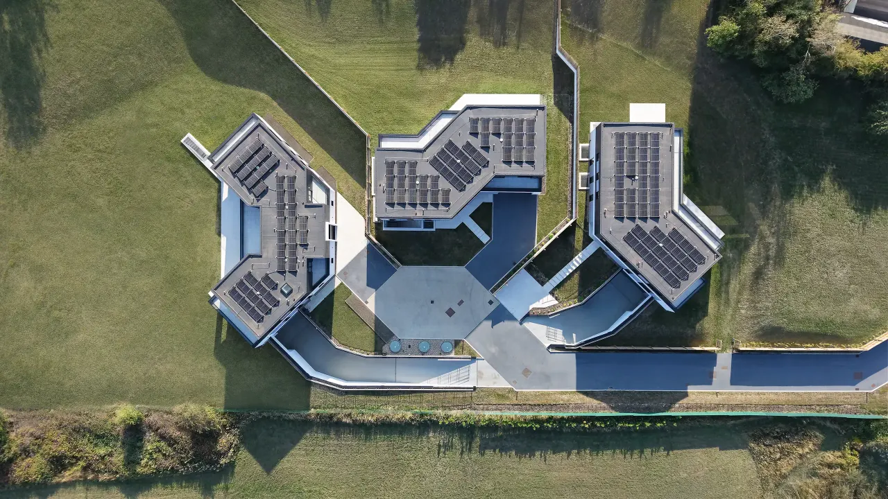 Aerial view of the three houses with solar panels on the roofs