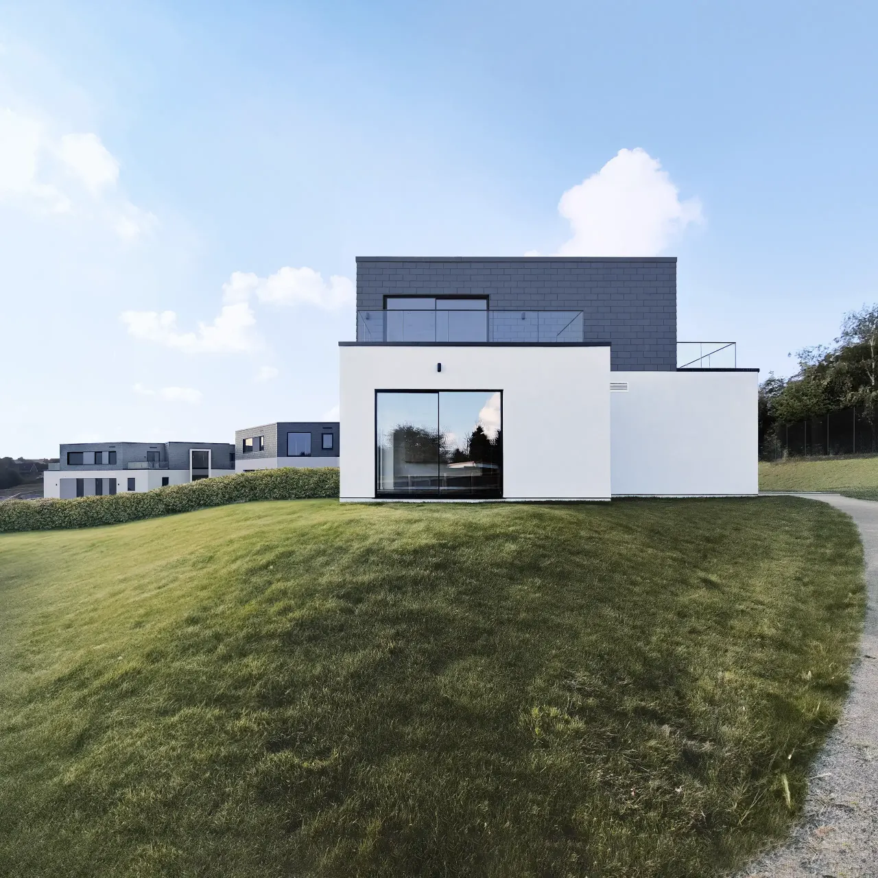 Grey slate and white render house on a grassy slope