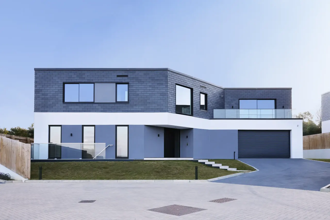 Front of a house with slate-clad upper floor, garage and driveway