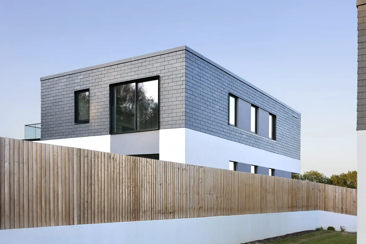 Slate-clad upper floor with large windows seen from below